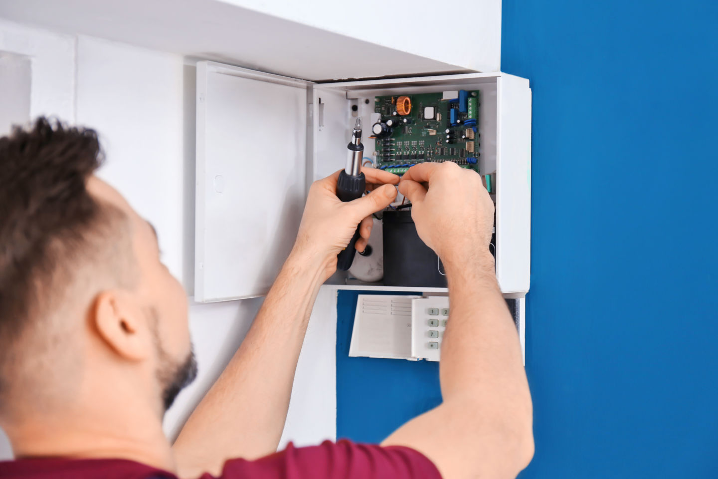 Electrician installing alarm system