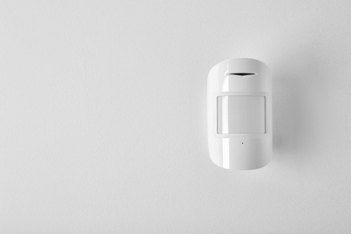 Modern motion sensor on wall indoors